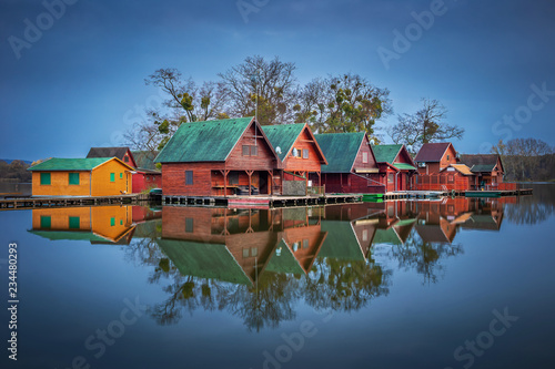 Fototapeta Tata, Hungary - Wooden fishing cottages on a small island at lake Derito (Derito