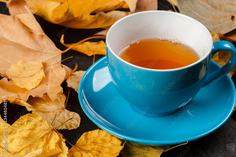 Cup of tea and autumn leaves on the table Cup of tea and autumn leaves on the table