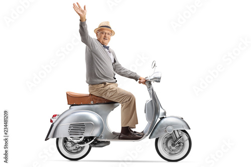 Senior gentleman riding a vintage scooter and waving at the camera
