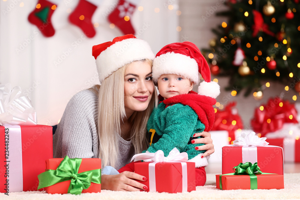 Mother and son in santa hats celebrate christmas at home Mother and son in santa hats celebrate christmas at home
