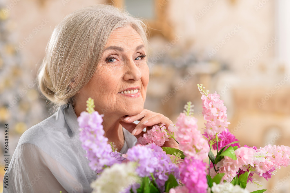 Portrait of beautiful senior woman posing with flowers Portrait of beautiful senior woman posing with flowers