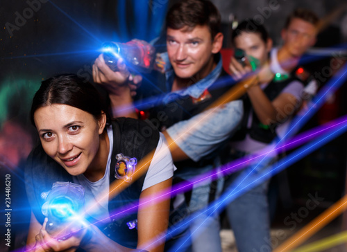 Group young people playing laser tag game