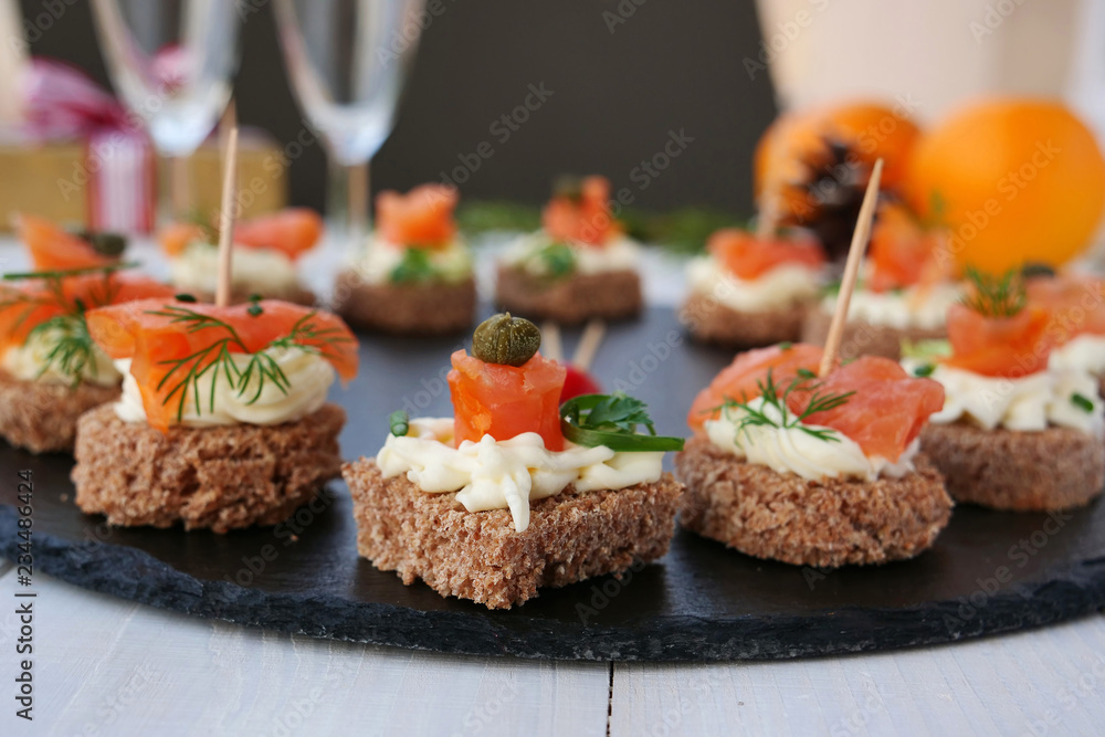Smoked salmon canapes with cheese cream and capers on rye bread