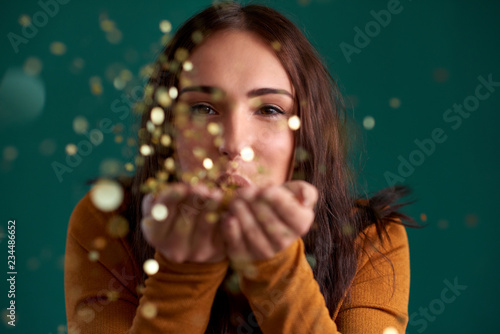 Schilderij op canvas Beautiful stylish woman blowing confetti party celebration