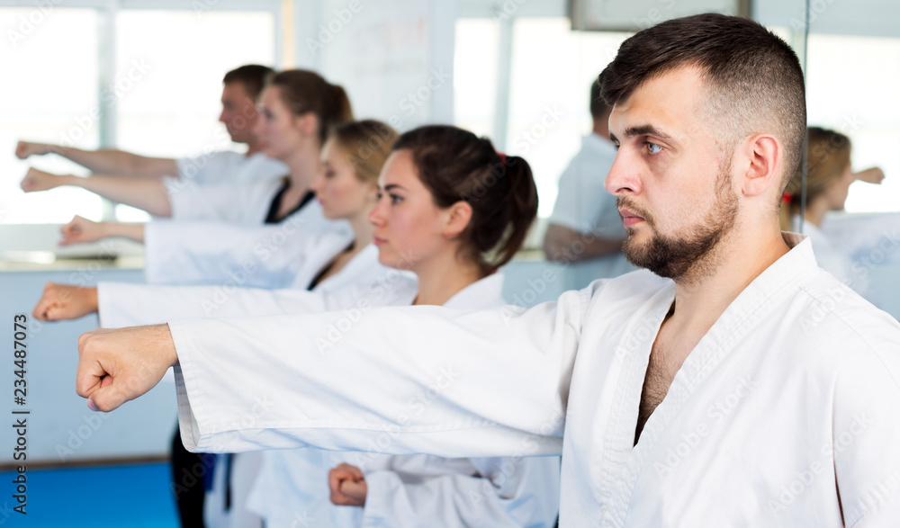 Fototapeta premium Adults trying new martial moves at karate class