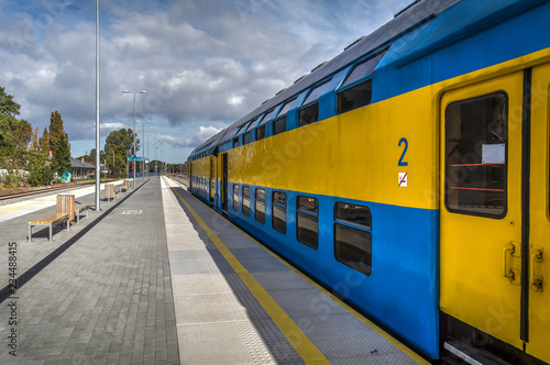 Blue and yellow train is ready to depart from platform on Hel peninsula station