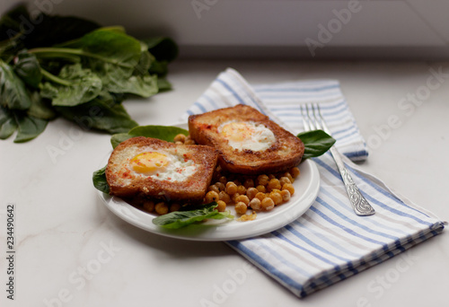 Toast with egg in white plate on white marble background. Healthy breakfast