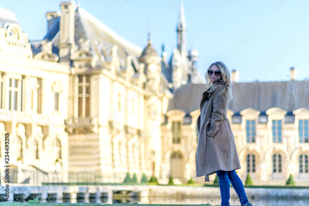 Woman at Chantilly Palace. Young tourist girl admiring the views. Portrait soft bokeh backgrounds