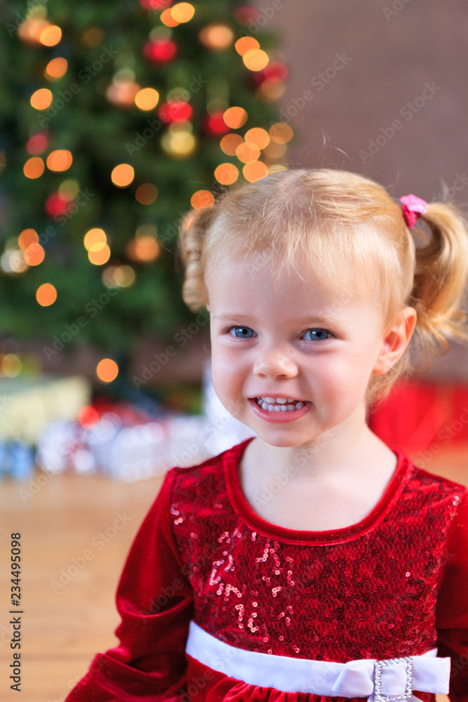 little miss santa smiling in front of the christmas tree little miss santa smiling in front of the christmas tree