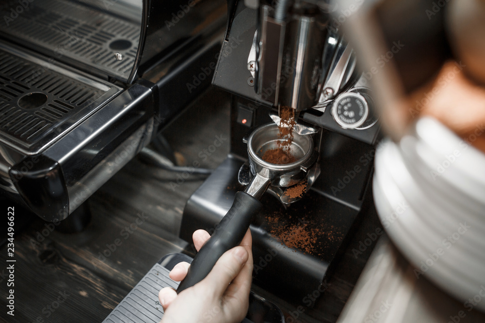 The process of grinding coffee professional machine for the bar in a modern cafe. Close-up The process of grinding coffee professional machine for the bar in a modern cafe. Close-up