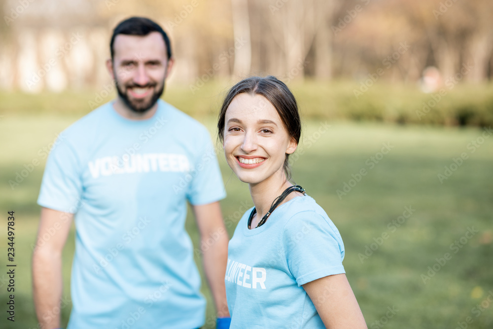Portrait of a happy volunteers in blue t-shirts in the park