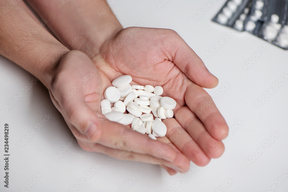 Handful of pills in men palms on white background Handful of pills in men palms on white background