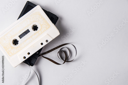 White and black audio cassettes on a light background. Place for text