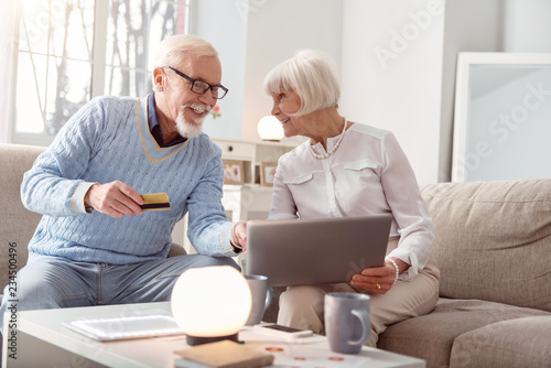 Payment process. Couple of baby boomers getting ready to pay for the goods while making purchase online