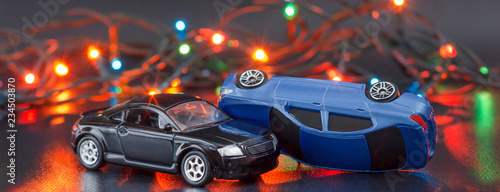 crash of two cars with christmas lights at background. accident statistics for new year. inverted car