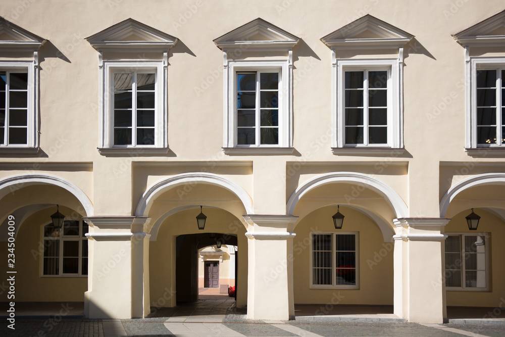 Traditional classic European restored building facade with columns and windows