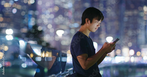 Photography Man use of cellphone in city at night