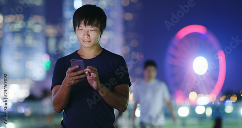 Man use of smart phone in city at night
