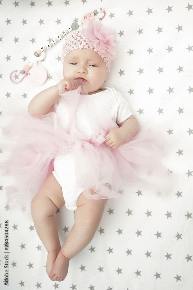 Fototapeta premium A Baby girl in white bedding at home look nice. learning newborn