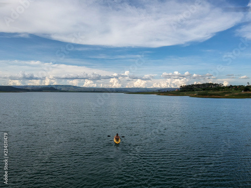 Aerial view of a young woman kayaking on a big lake