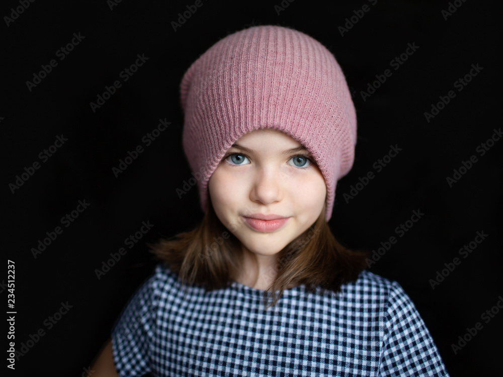portrait of a cute preteen girl in a hat on a dark background portrait of a cute preteen girl in a hat on a dark background