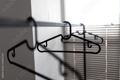 Simple metal clothing rail with empty coat hangers. Shop or boutique concept.