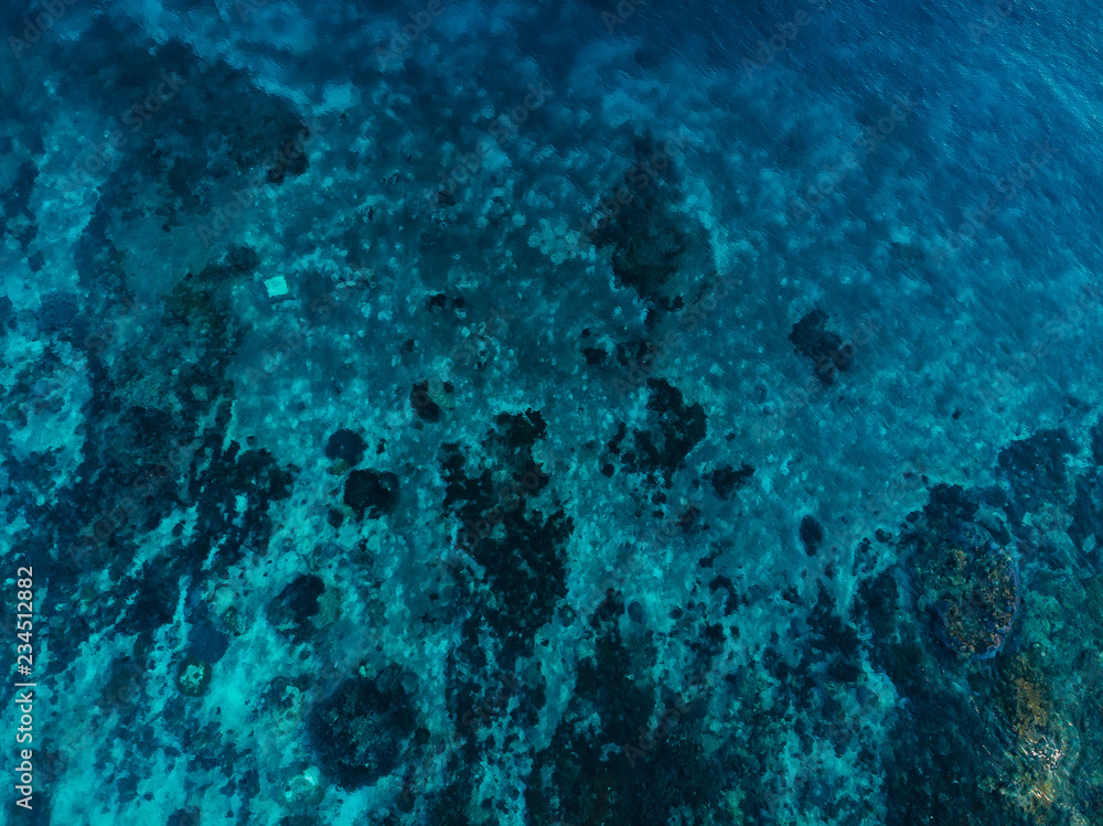 Turquoise ocean with coral reef, aerial drone shot. Top view. Ocean background