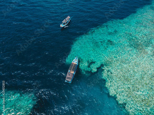 Tour boats in blue ocean on Menjangan island. Aerial view.