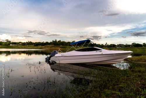 Motor boat parked on a river shore © Henrique