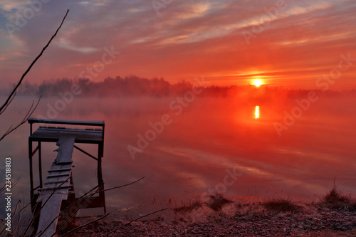 Fishing bridge at the background of beautiful sunrise at the lake