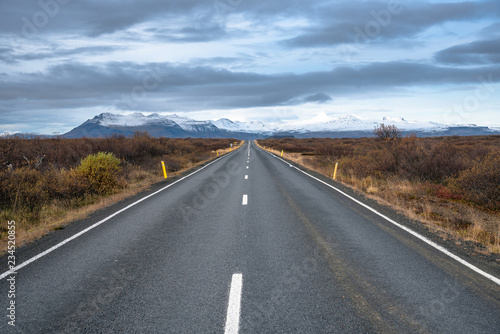 Empty Stretch of a Road Leading to Snow Covered Mountains in Iceland in Autumn photo