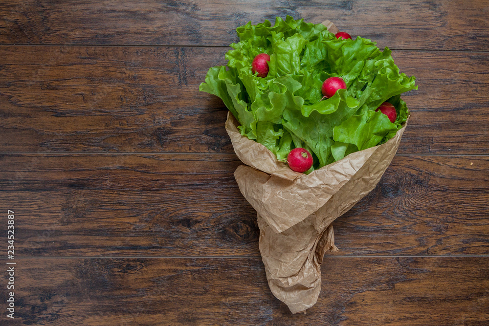 Fresh green vegan vegetarian salad with radish in paper package 