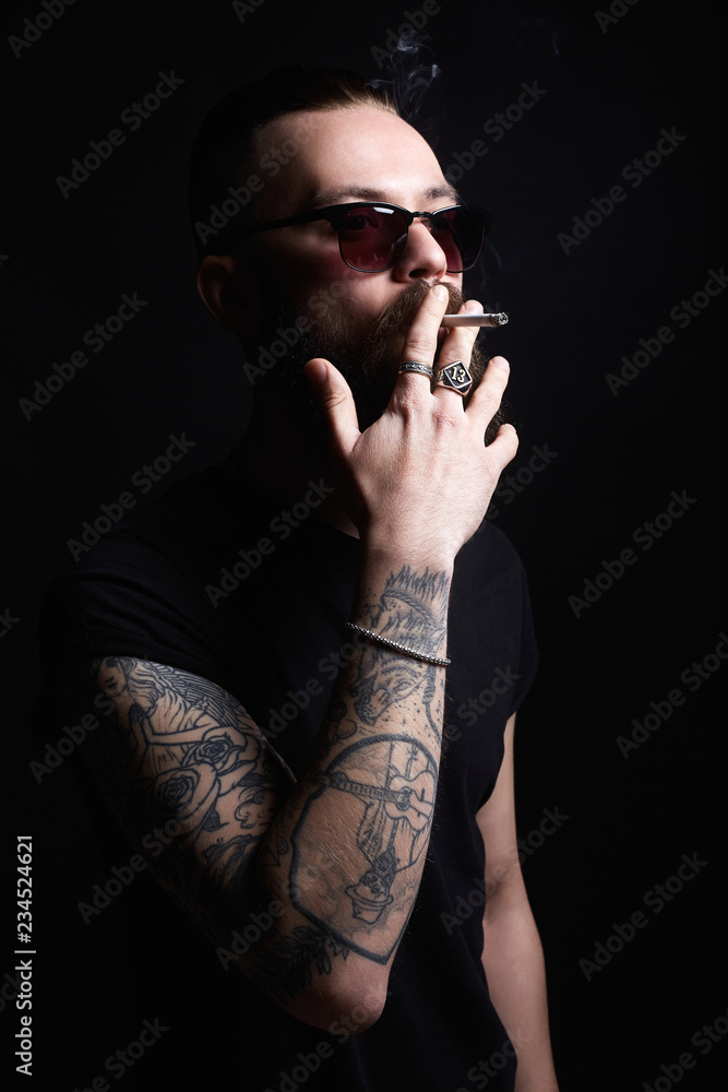 Brutal bearded smoking man in sunglasses Brutal bearded smoking man in sunglasses