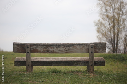 Holzbank zum ausruhen für Picknick vor Wiese mit viel Horizont