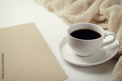 A Cup of fragrant black coffee and a textured wool blanket. Warm tone