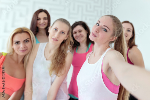 Group of young women dressed in sportswear taking selfie together