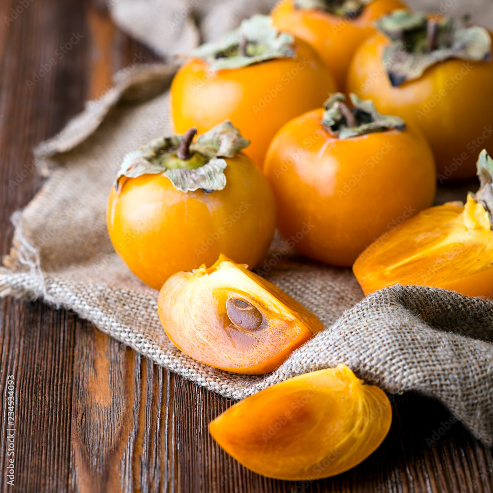 Persimmon, sliced, cut, rustic retro style, wooden background