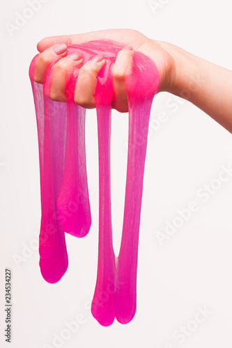 a toy for children mucus and liquid flowing on hand on a white background