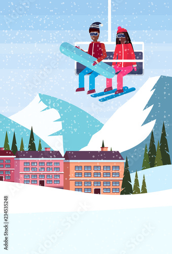 african american couple skiers on chairlift ski resort hotel houses buildings winter snowy mountains landscape flat vertical
