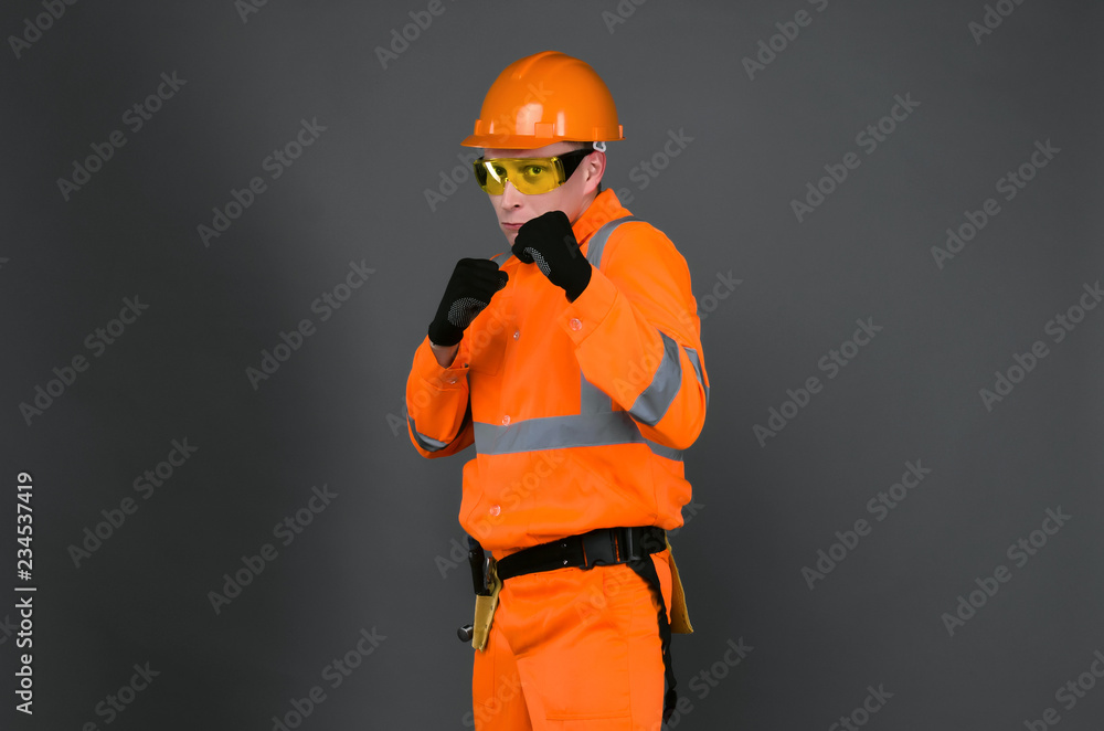 Aggressive worker man is standing in a defensive stance covering his face with fists. Defend interests in building industry. Aggressive worker man is standing in a defensive stance covering his face with fists. Defend interests in building industry.