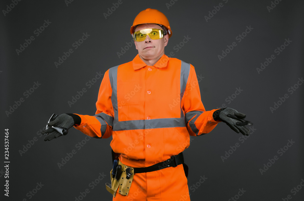 Guilty builder worker justifies about lateness of construction and spreads his hands isolated on blue background. Construction mistake.