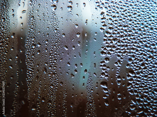 Drops of water on a cold glass.