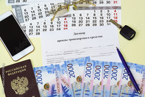 Document in Russian vehicle rental Agreement, Russian passport, Russian banknotes, keys, smartphone and glasses