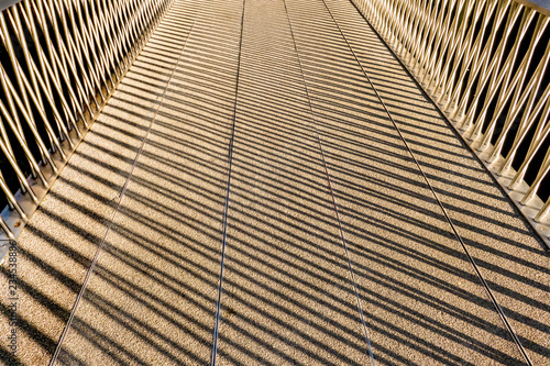 shadows of a handrail on a footbridge making abstract patterns in London England