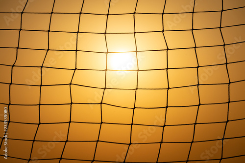 Football goal net at sunset with sun photo