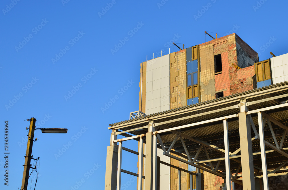 Building construction. Concrete structure beam column slab. Warming of the facade, plastering of a brick wall, with cement material structure. Industrial warehouse hangar interior Building construction. Concrete structure beam column slab. Warming of the facade, plastering of a brick wall, with cement material structure. Industrial warehouse hangar interior