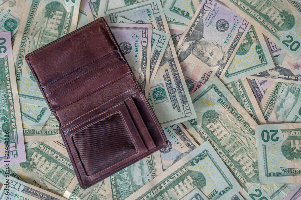 Open brown leather man wallet on dollar background Open brown leather man wallet on dollar background
