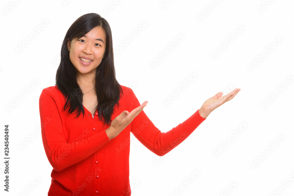Portrait of young happy Asian woman showing something Portrait of young happy Asian woman showing something