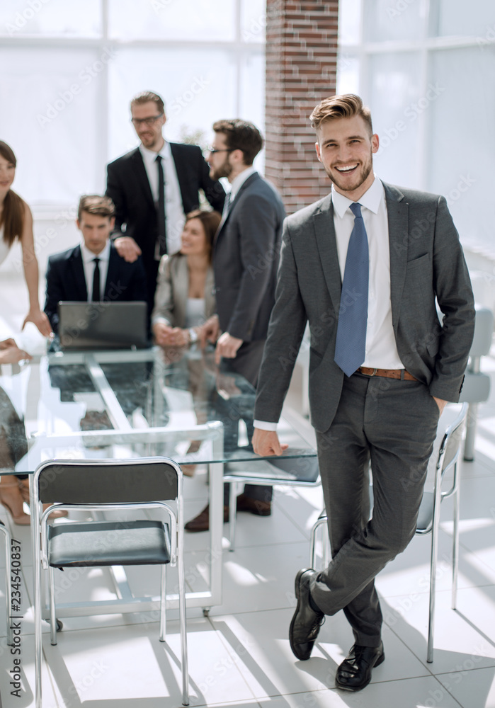 in full growth.young businessman standing in a modern office in full growth.young businessman standing in a modern office