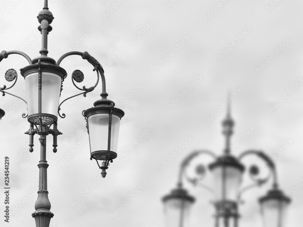 Metal outdoor lanterns against the sky in black and white shot